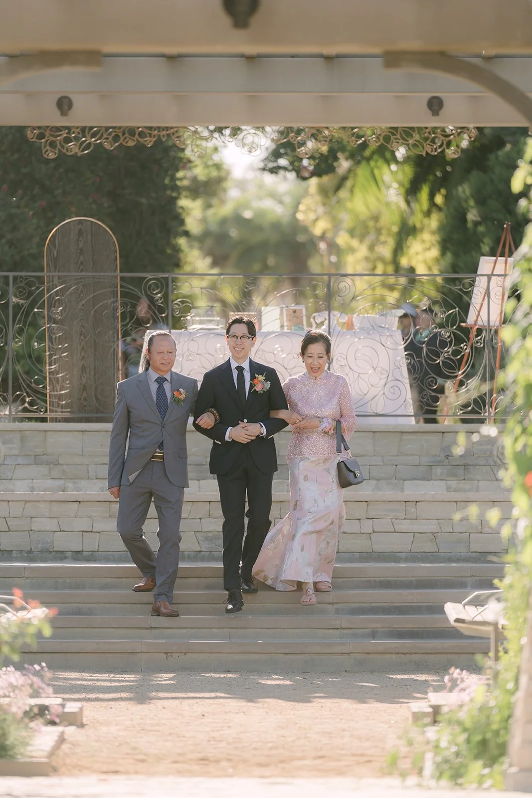 Leroy descending the stone steps escorted by his parents