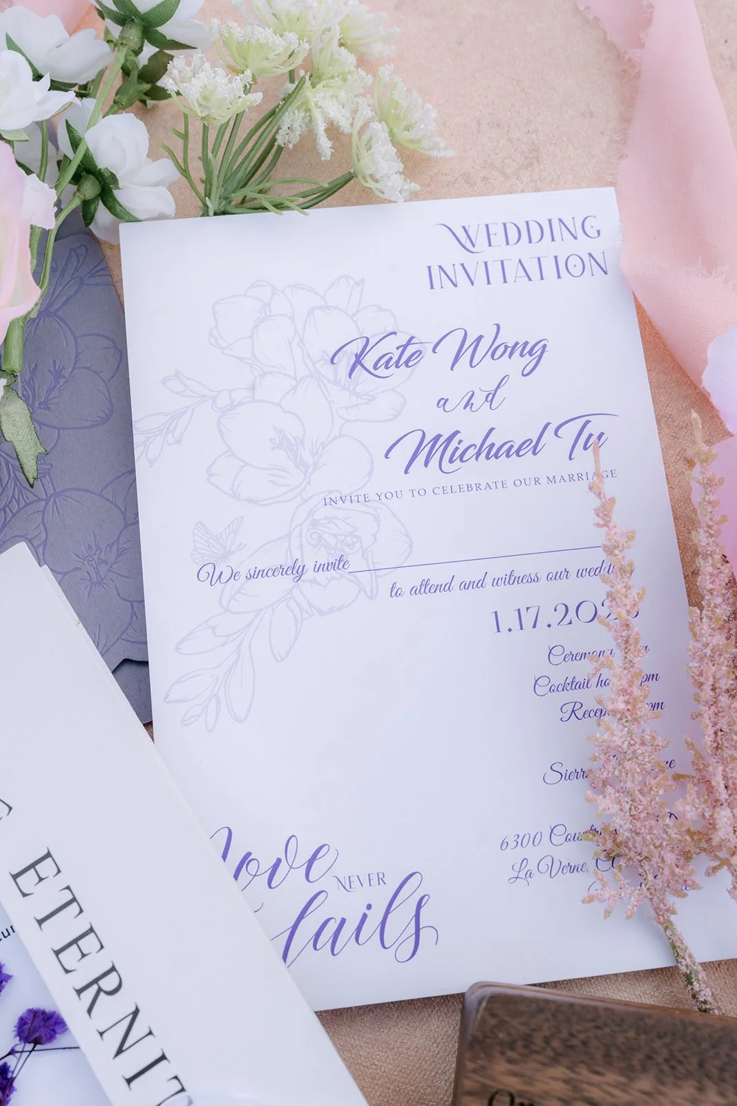Kate and Michael's wedding invitation styled with pink florals.