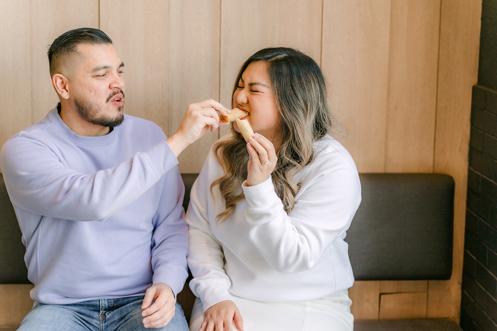 Linh and Ankush share a bite on the bench.