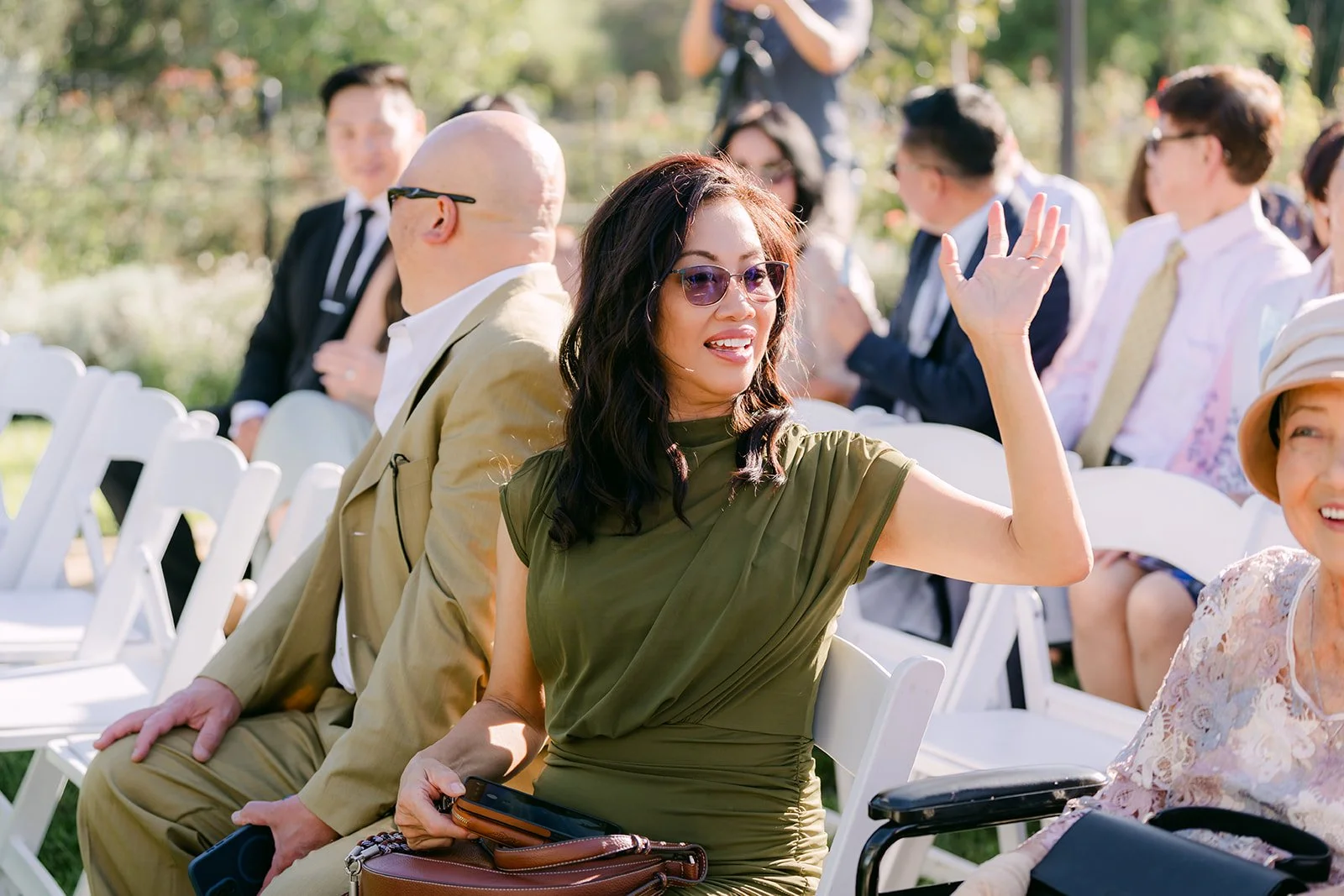 A guest waving hello across the ceremony seating