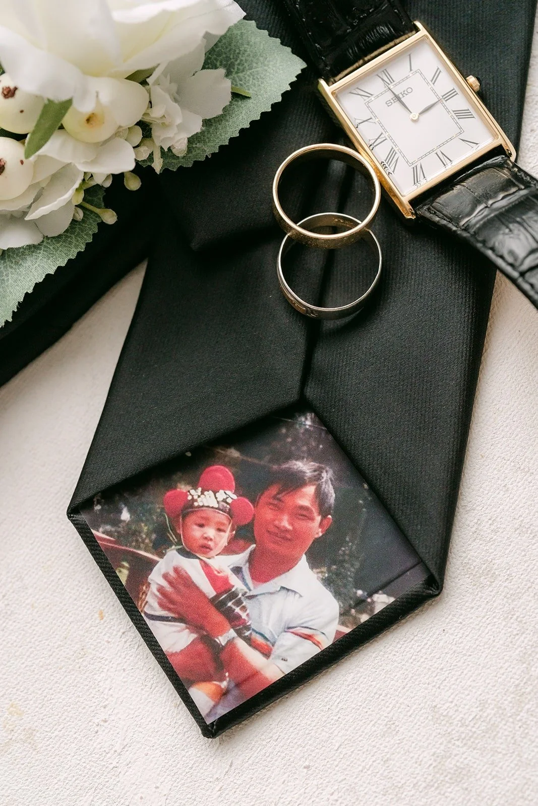 Wedding bands, a watch and a childhood photo on Yao's tie