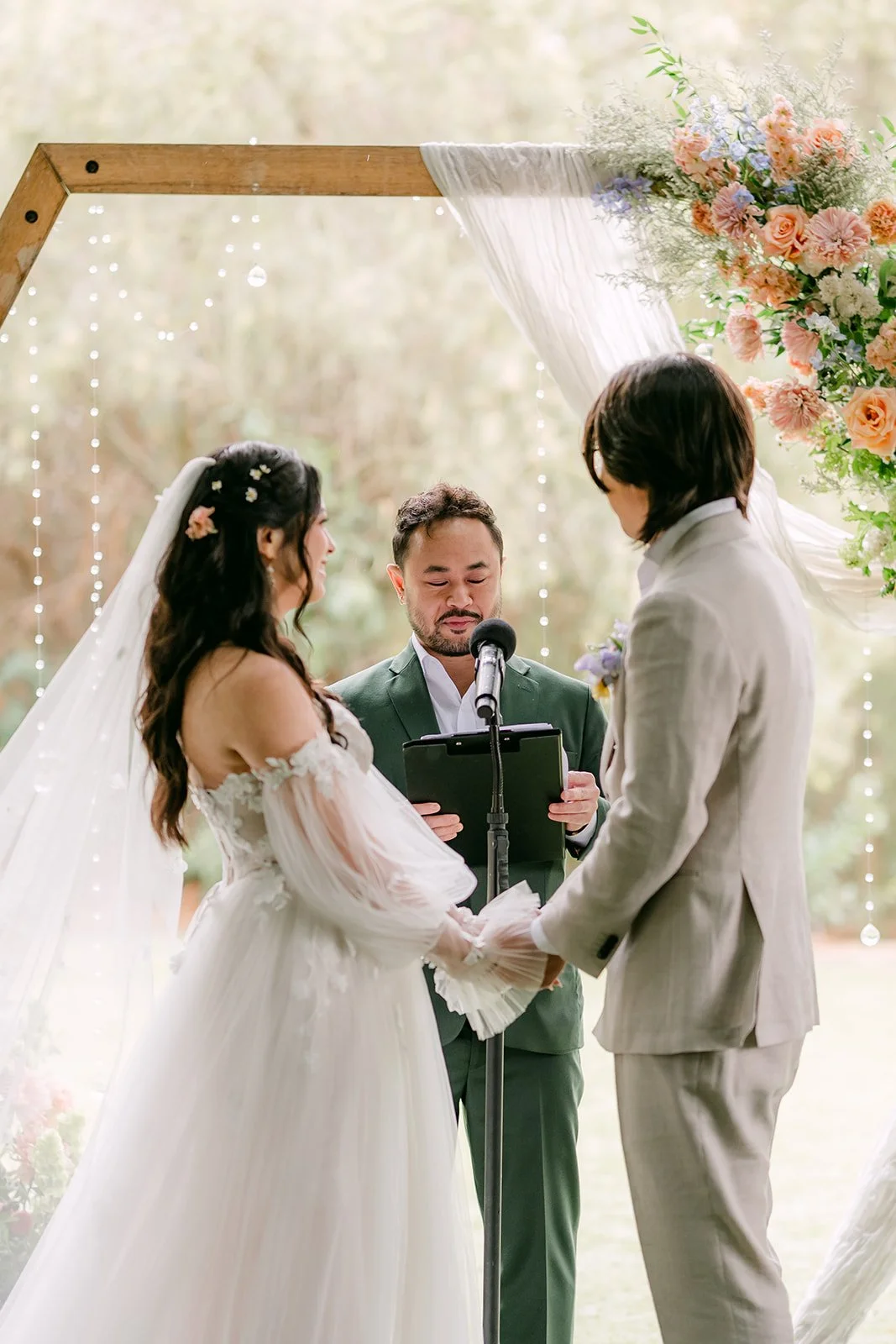 Kat and Mike at the hexagon arch as their friend officiates