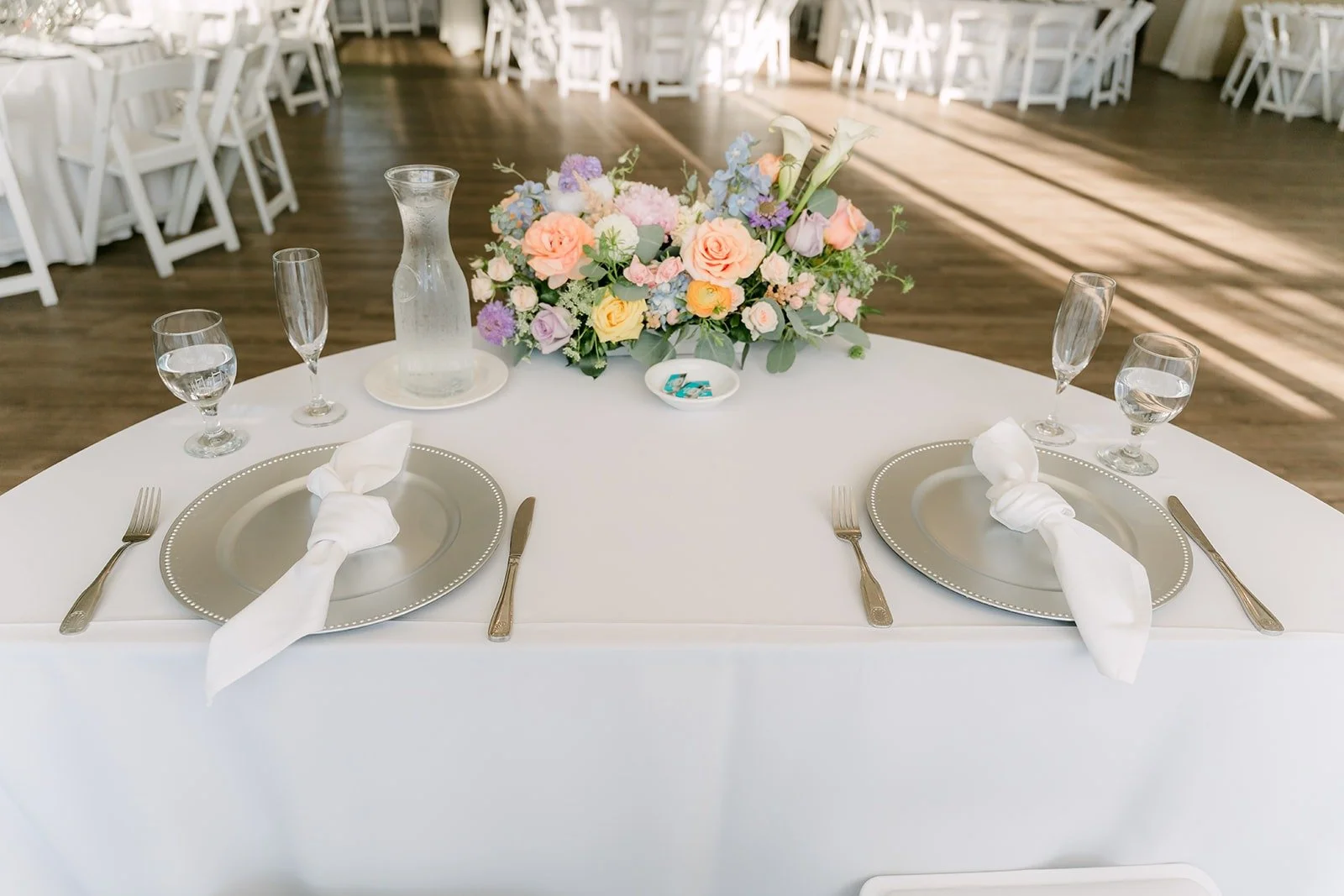 A place setting with folded napkins and a small floral centerpiece