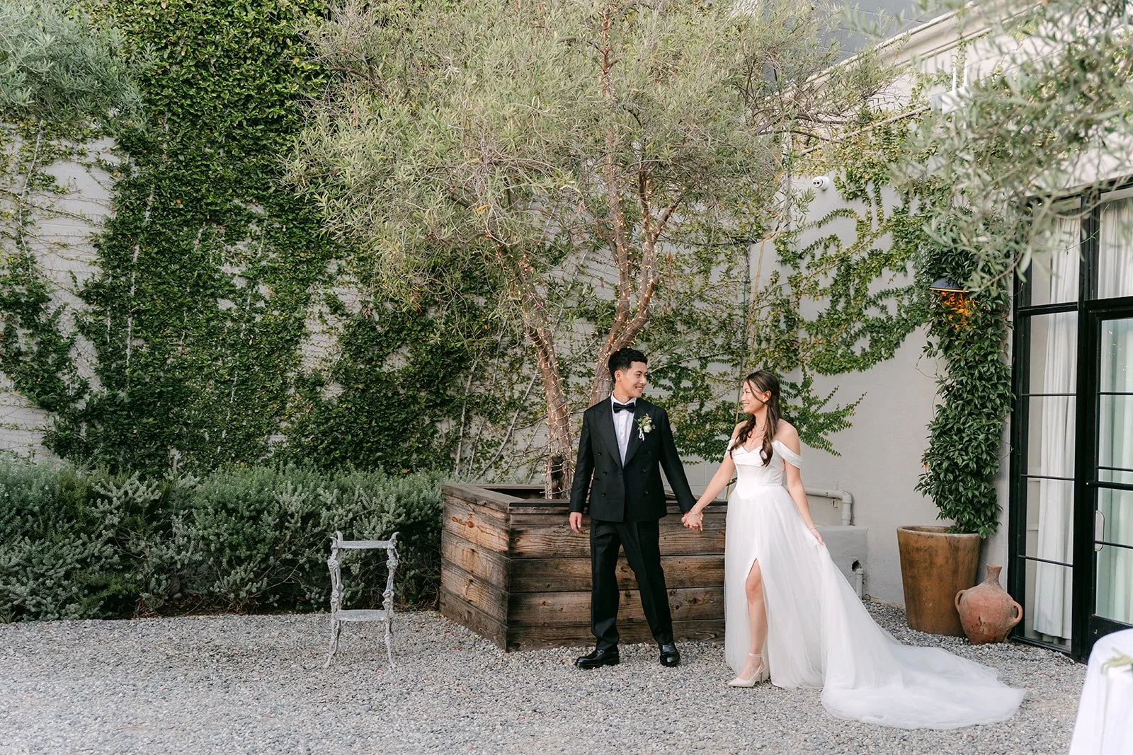 Jadee and Richard by the ivy covered wall in the courtyard, photographed by One and Only Production