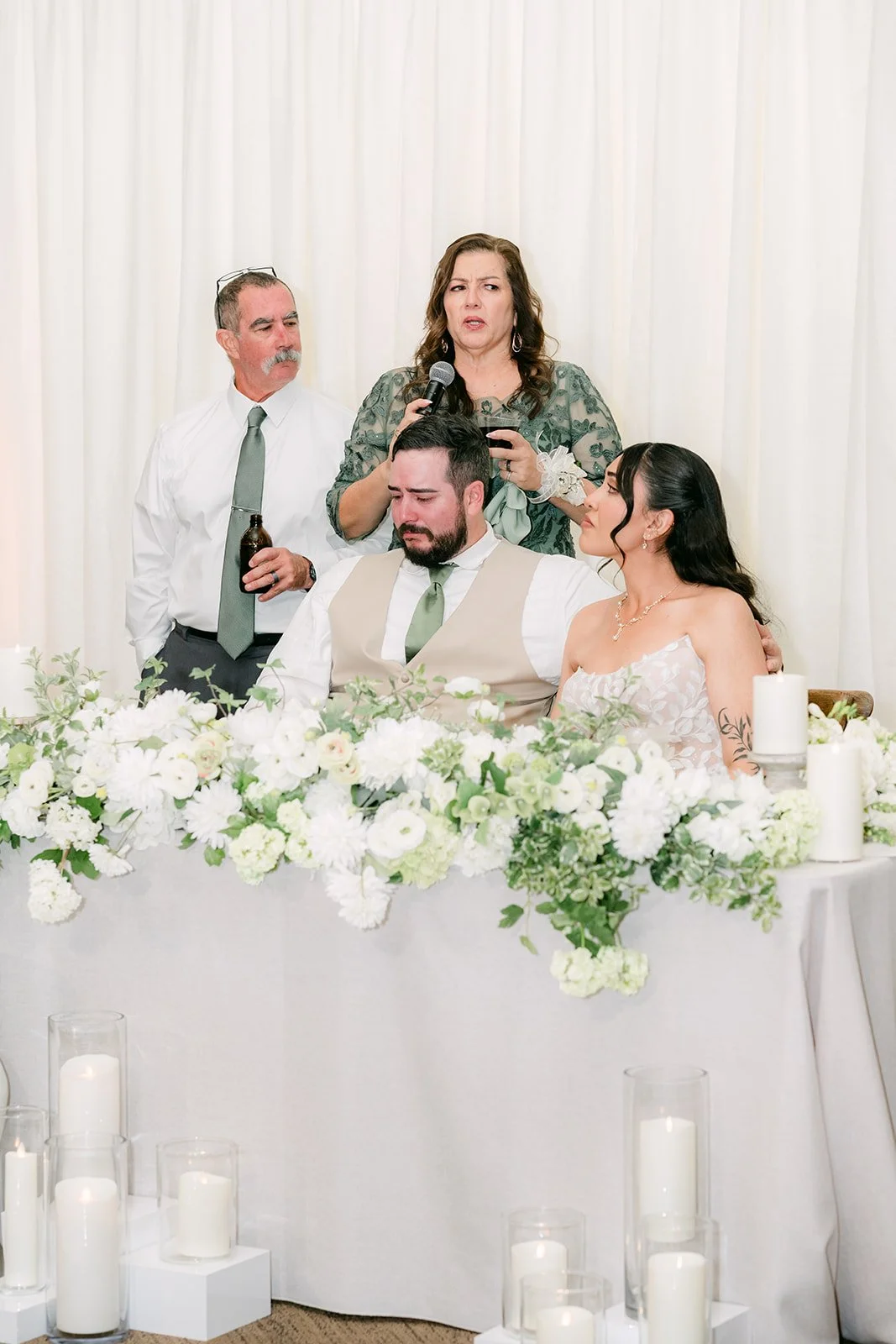 Fernanda and Cody listening to a speech at the sweetheart table.