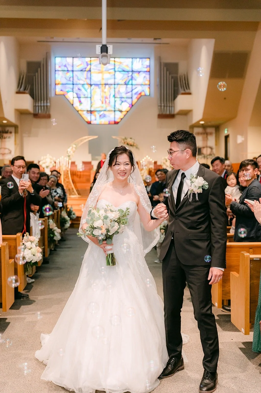 Eunice and Eric walk back up the aisle to cheering guests