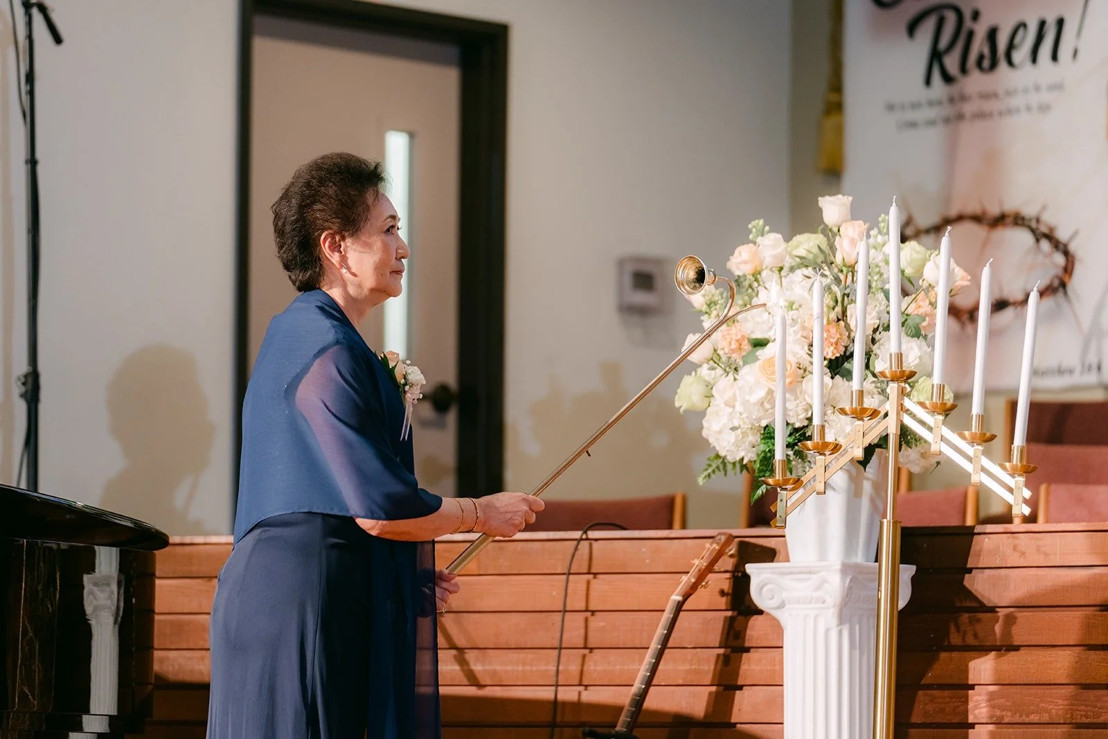 A mother of the couple lights a candle at the start of the ceremony