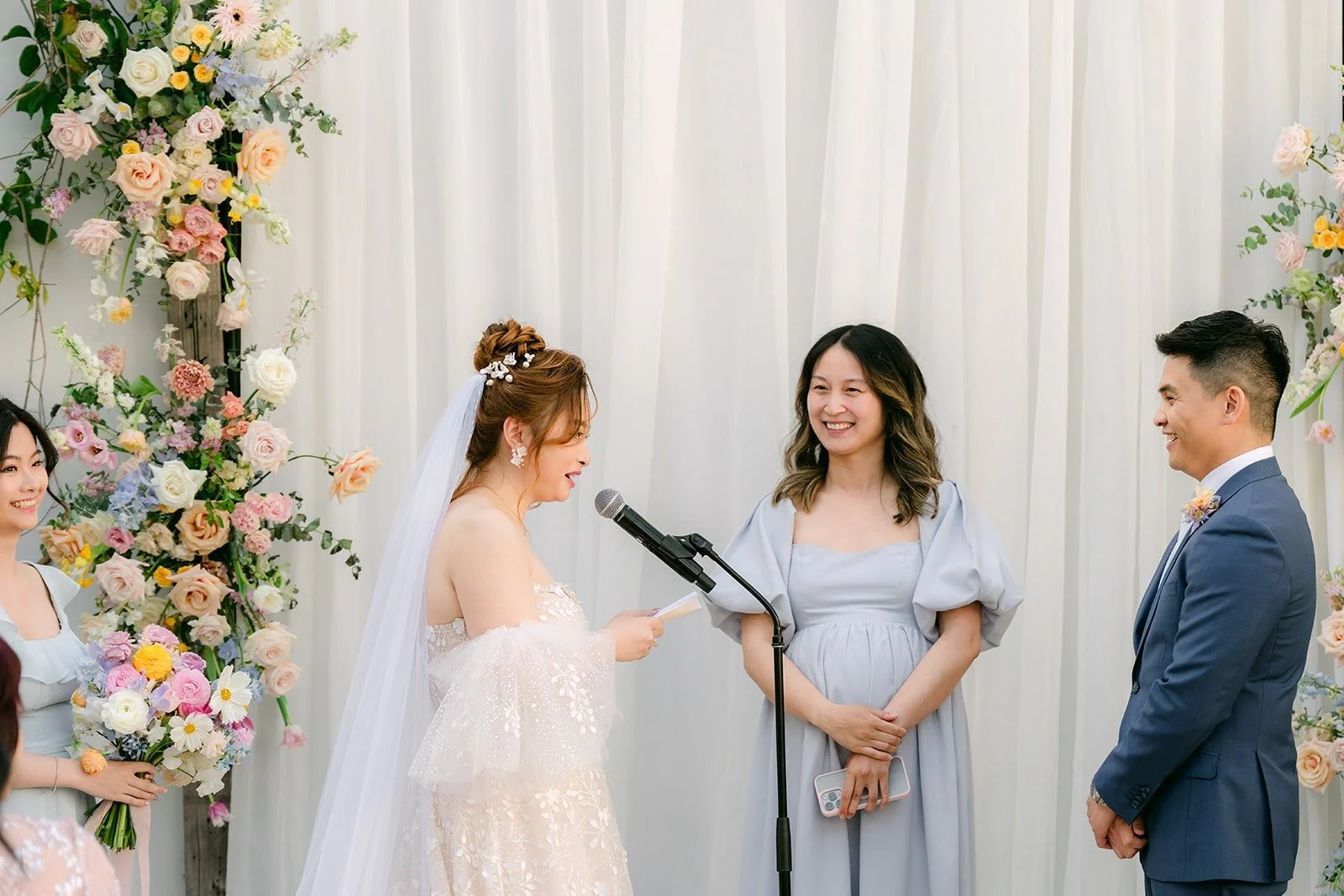 Joanna and Jerrick facing each other with their officiant during the ceremony