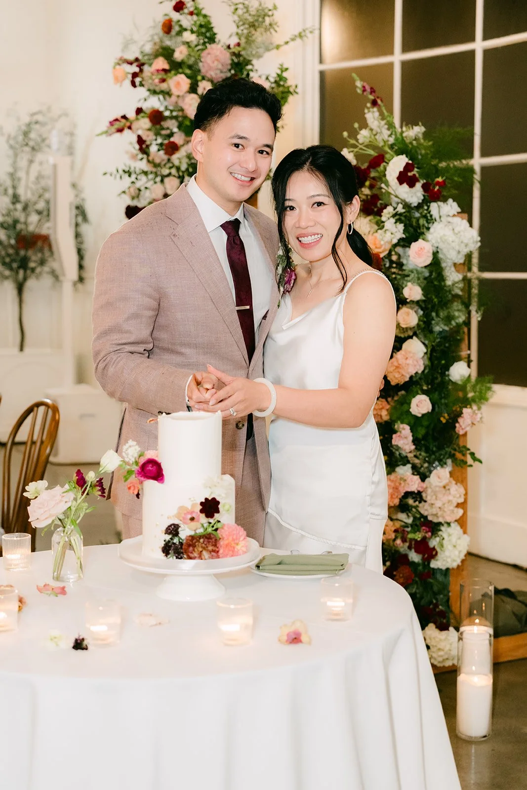 Denise in her second look and Michael smiling behind the cake.