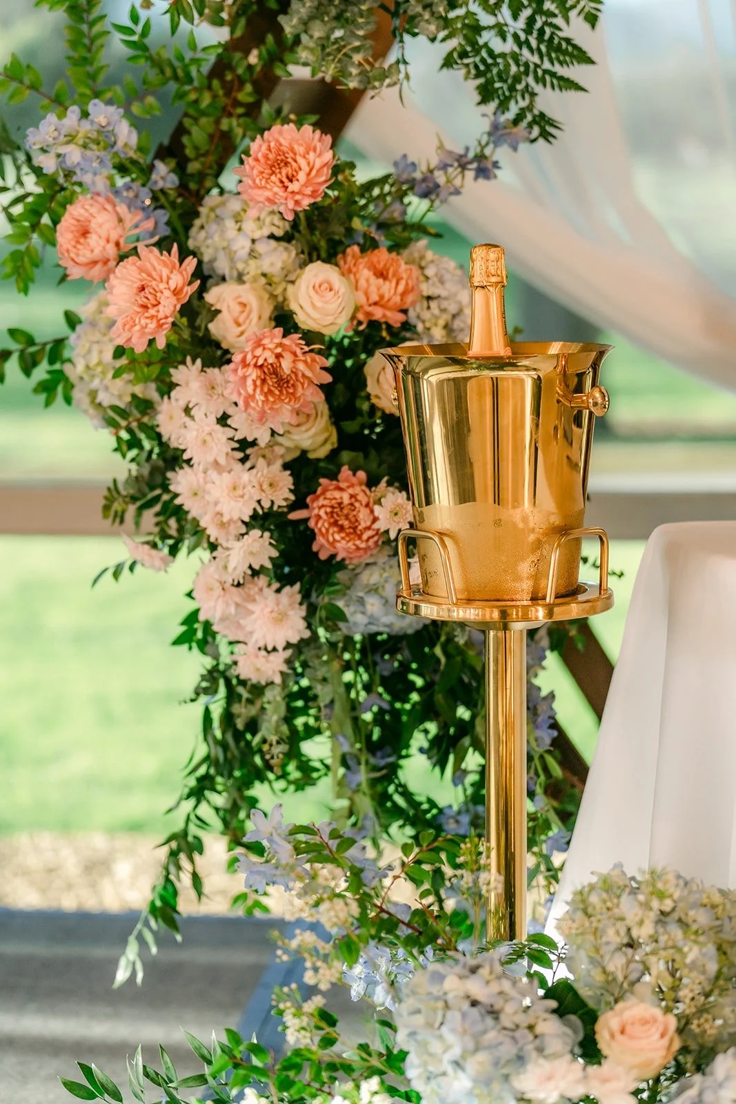 Peach and blush florals with a gold champagne bucket