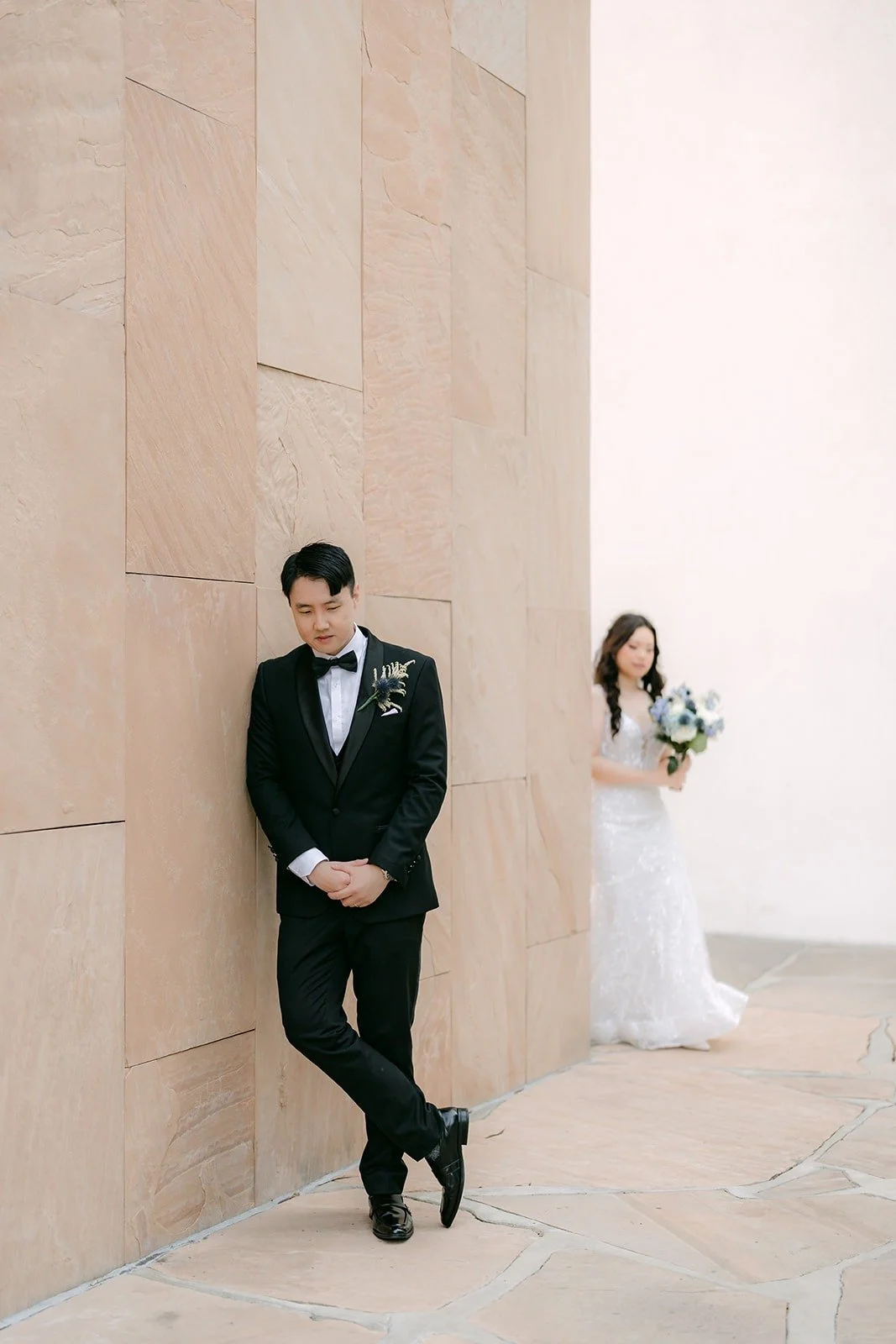 James leaning on the sandstone wall as Emily walks toward him