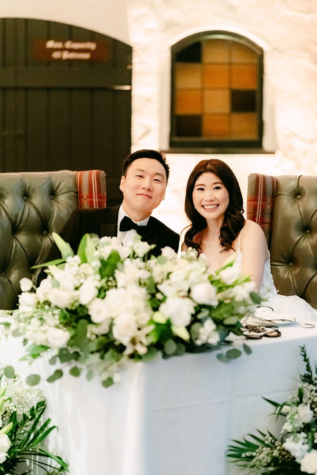 Valerie and Jason laughing at the sweetheart table, photographed by One and Only Production