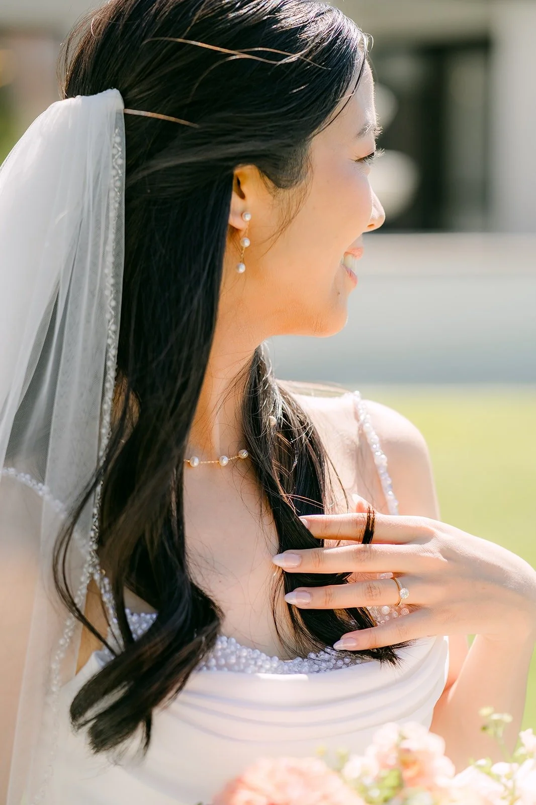 A close view of Stephanie's earring and veil as she looks over her shoulder