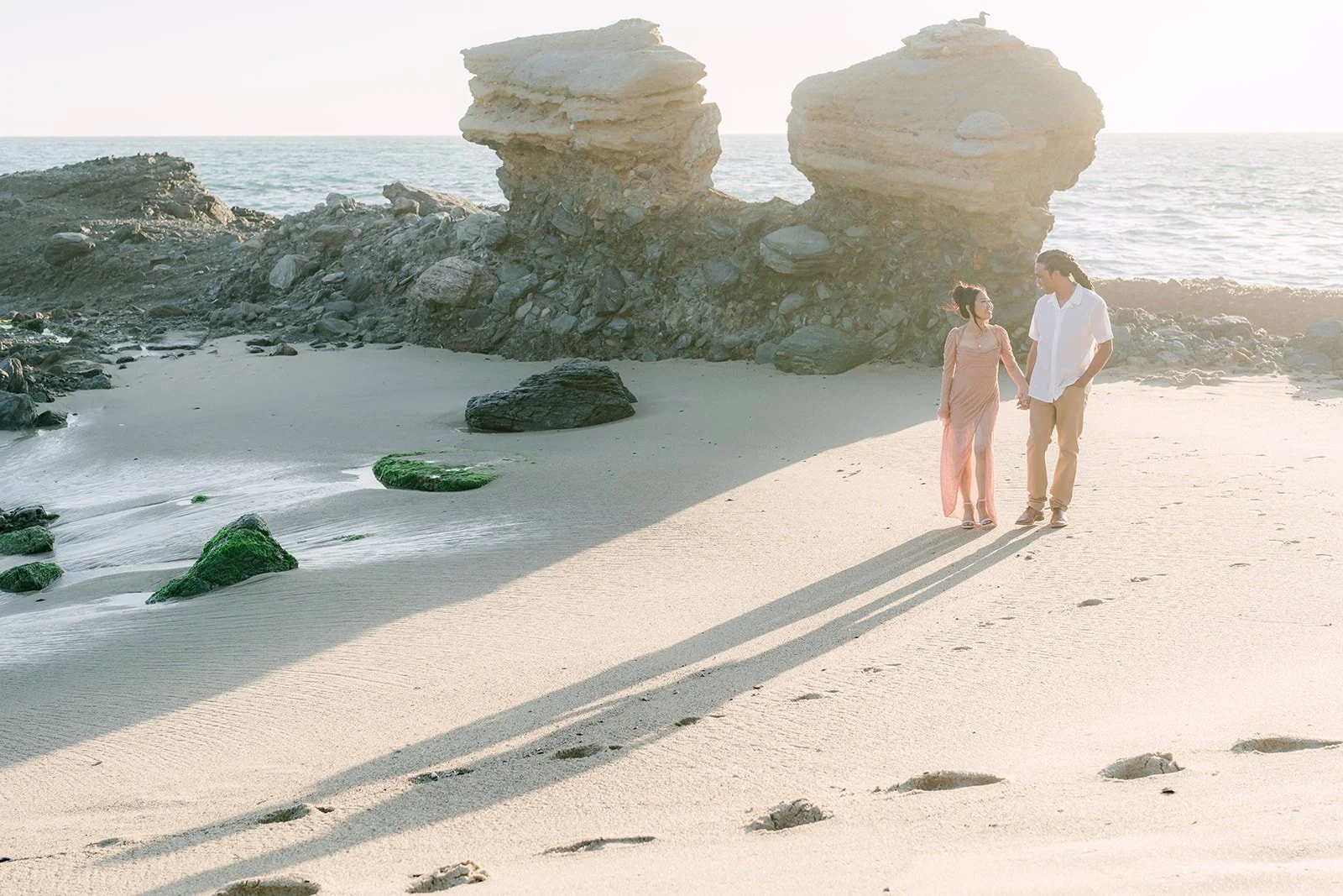 Amy and Michael on the sand with the Table Rock formation behind them.