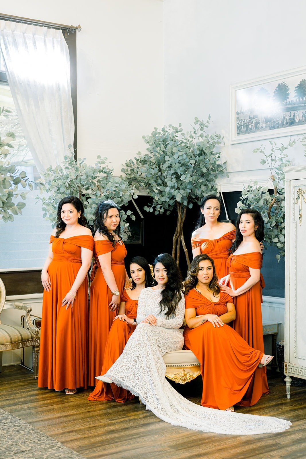 Hannah with her bridesmaids in burnt orange gowns in the bridal suite