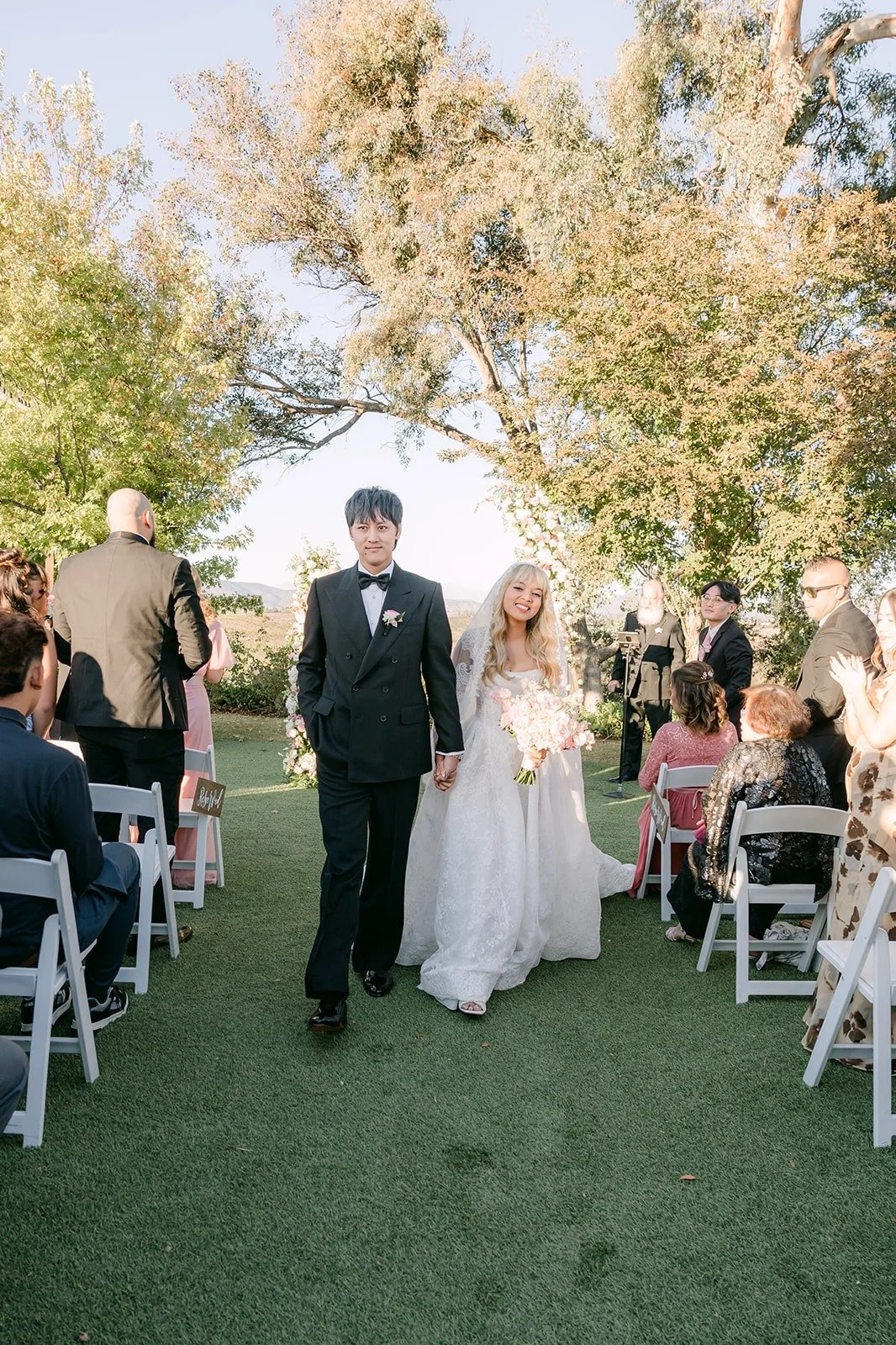 Konitha and Job walking back up the aisle as husband and wife