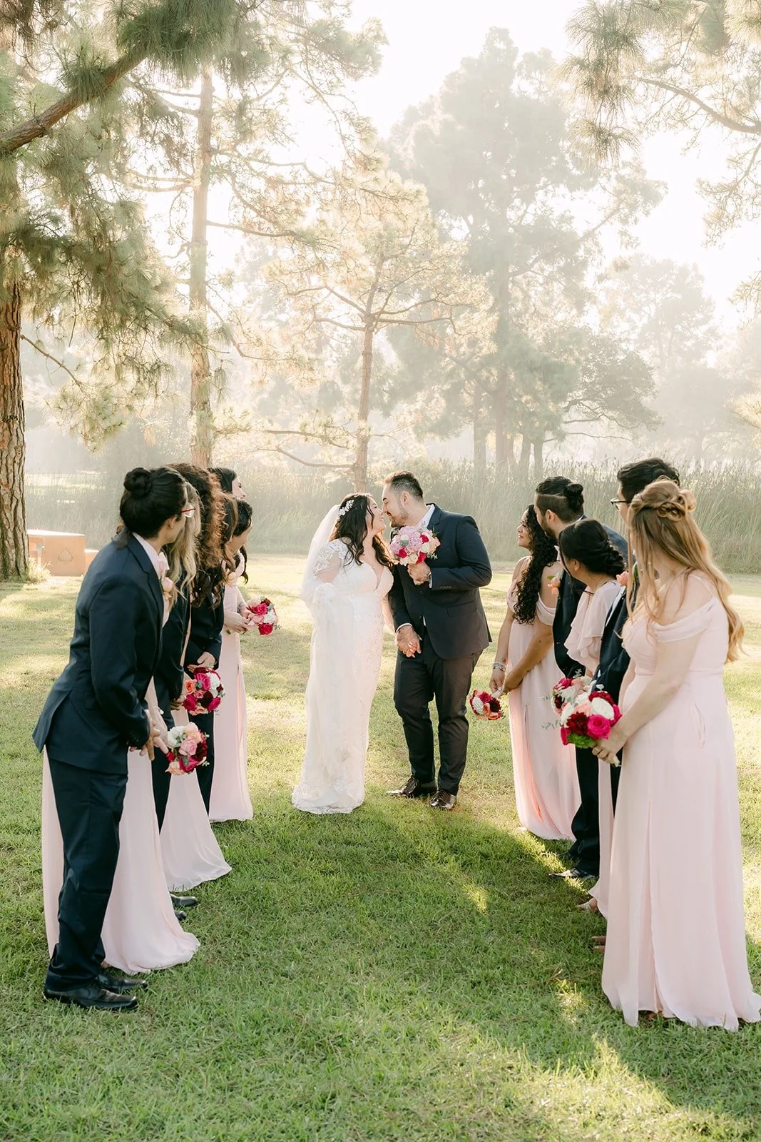 Wedding party walking and laughing together across the grass