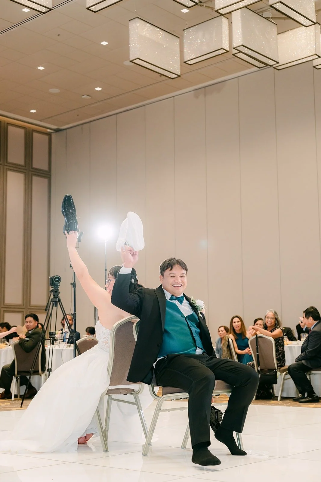 James holding up a shoe as he answers, photographed mid laugh