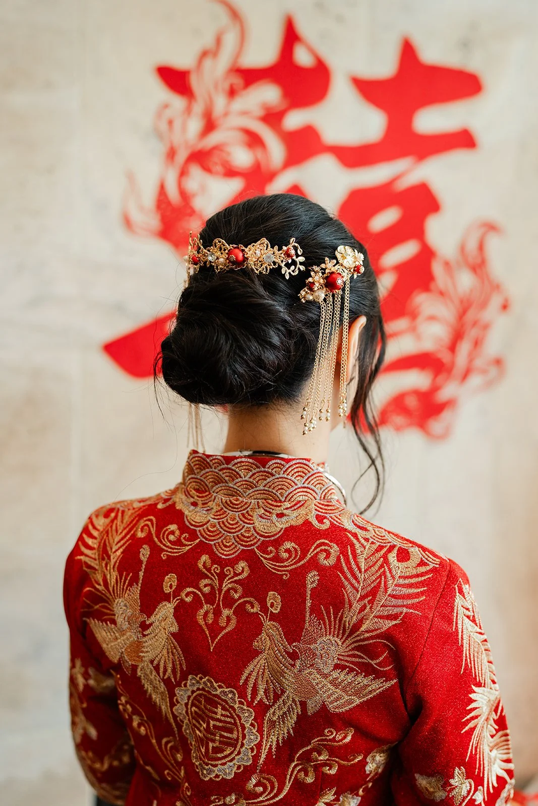 The back of Bridgette's qun kwa and gold hair pins under a double happiness sign.