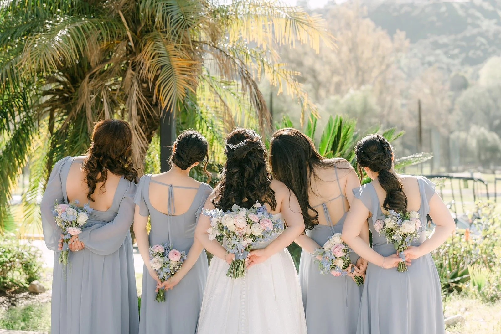 Florence and her bridesmaids walking away across the lawn
