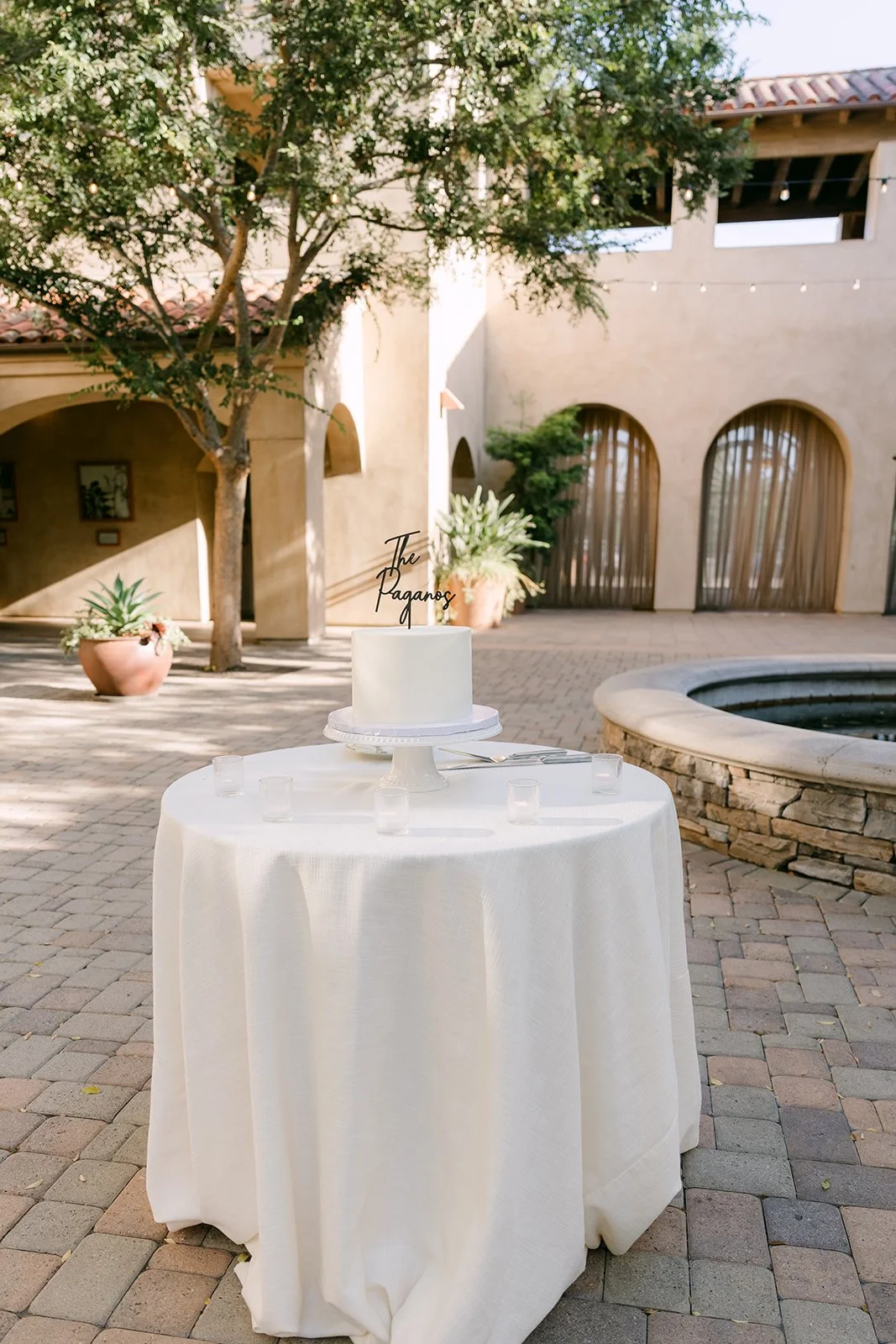 Wedding cake on a round table beside the fountain