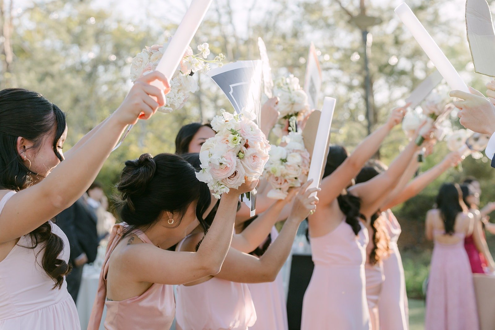 Bridesmaids cheering with raised arms as the newlyweds arrive
