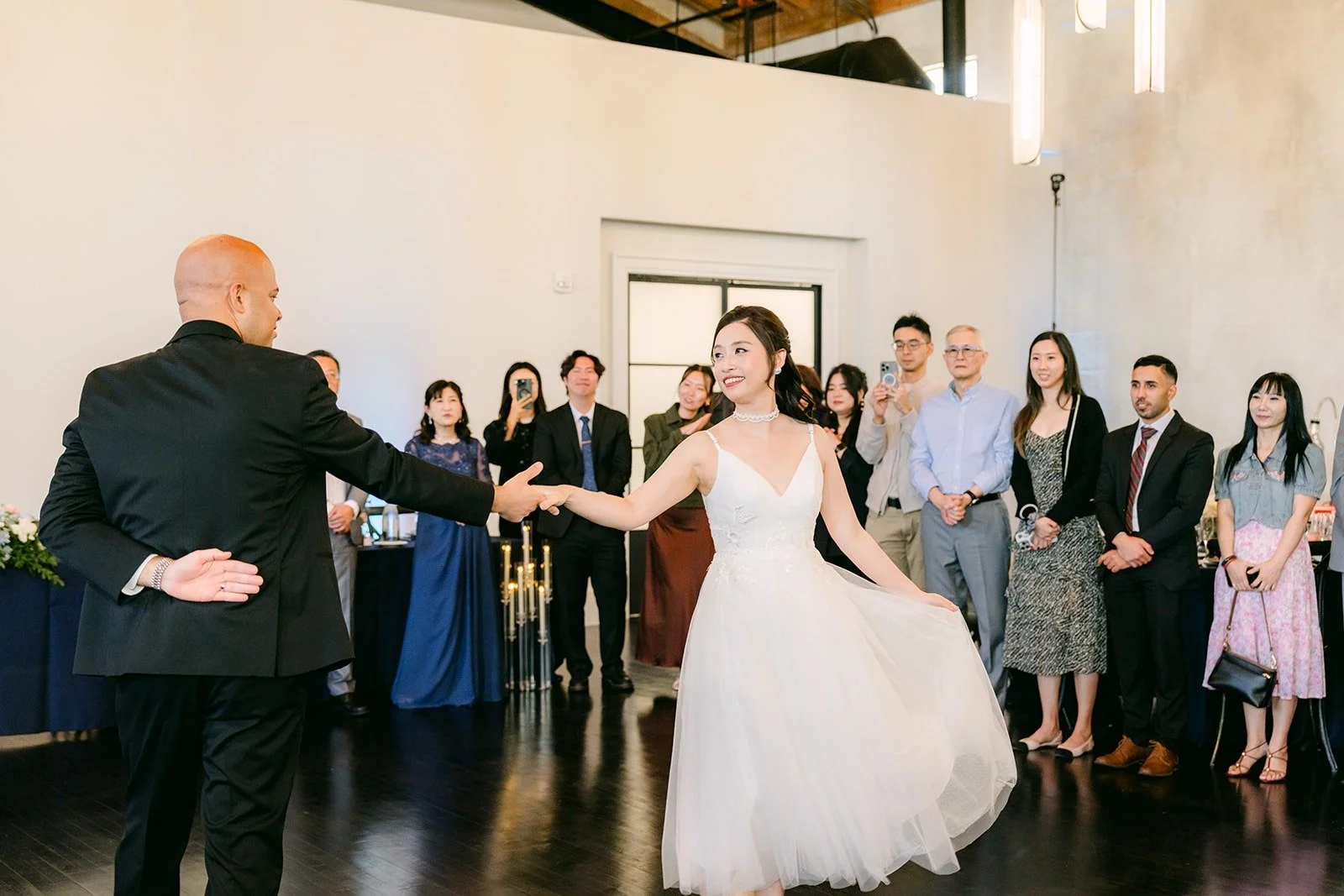 Elisa and Brandon dance side by side under the wood beam ceiling