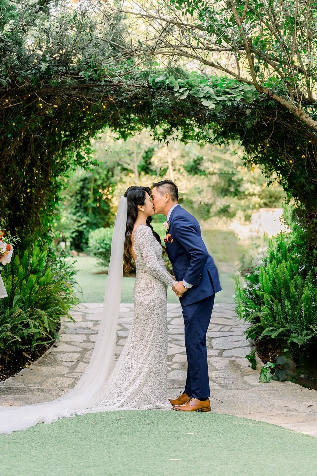 Hannah and Vincent sharing their first kiss under the arbor