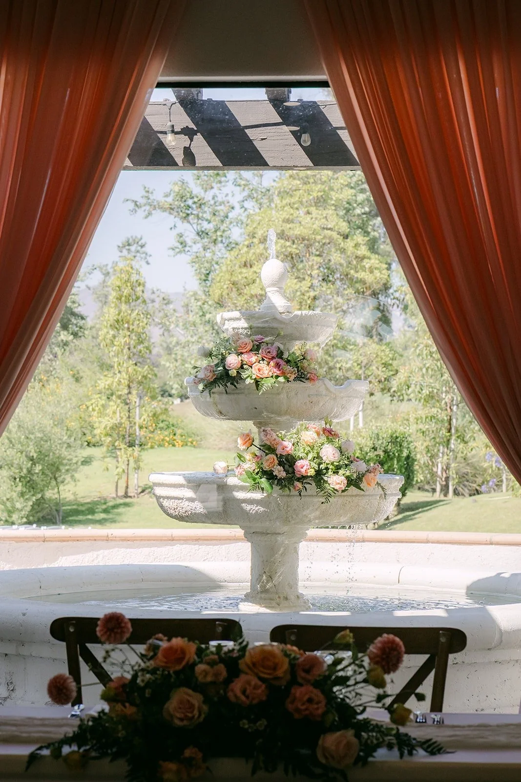 The fountain framed by rust colored curtains, seen through a doorway at Sterling Hills