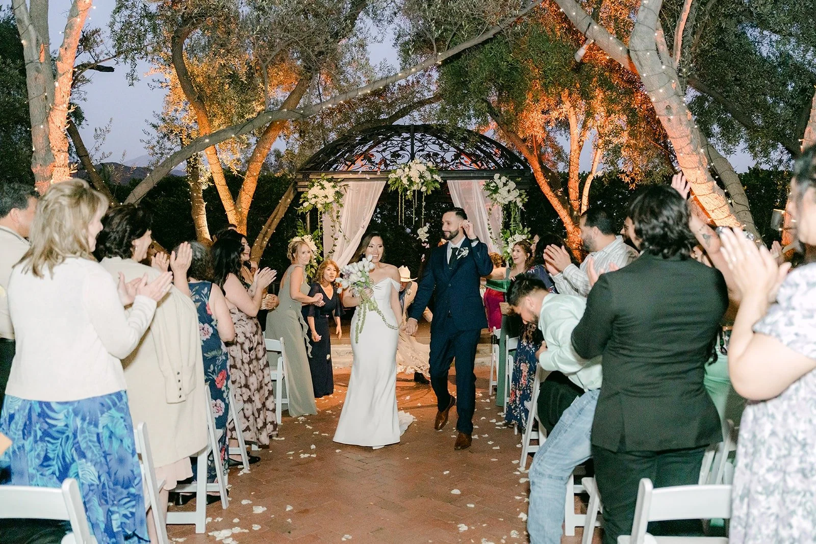 Mariana and Danny walking back up the aisle as guests cheer