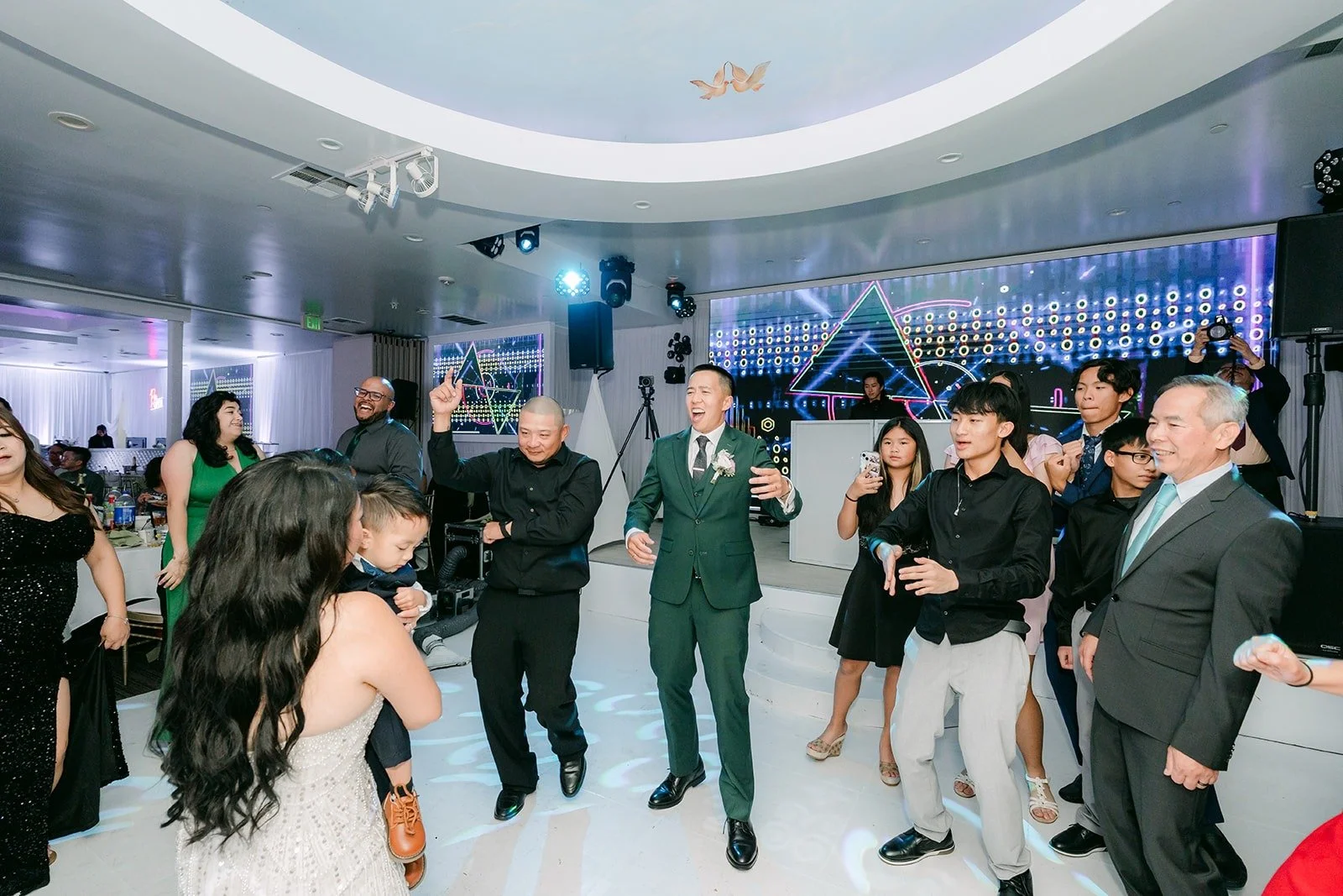 Jennifer and Kevin dance with their guests under the reception lights