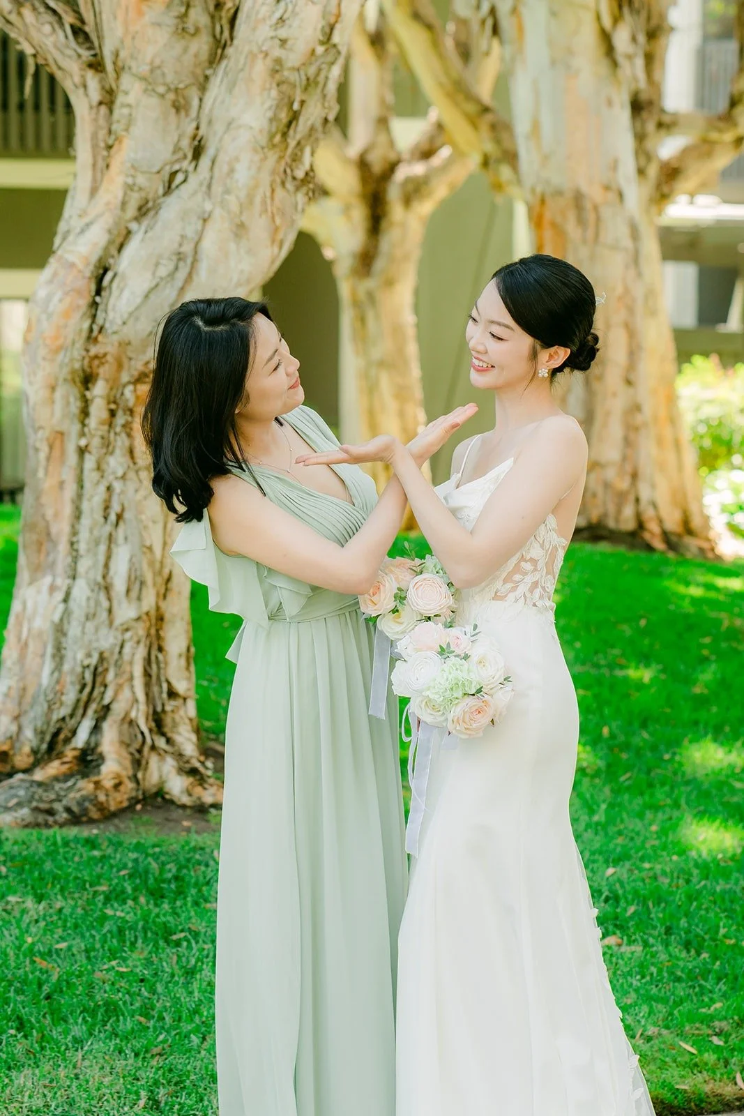 A bridesmaid fixing Tin's bouquet under the trees