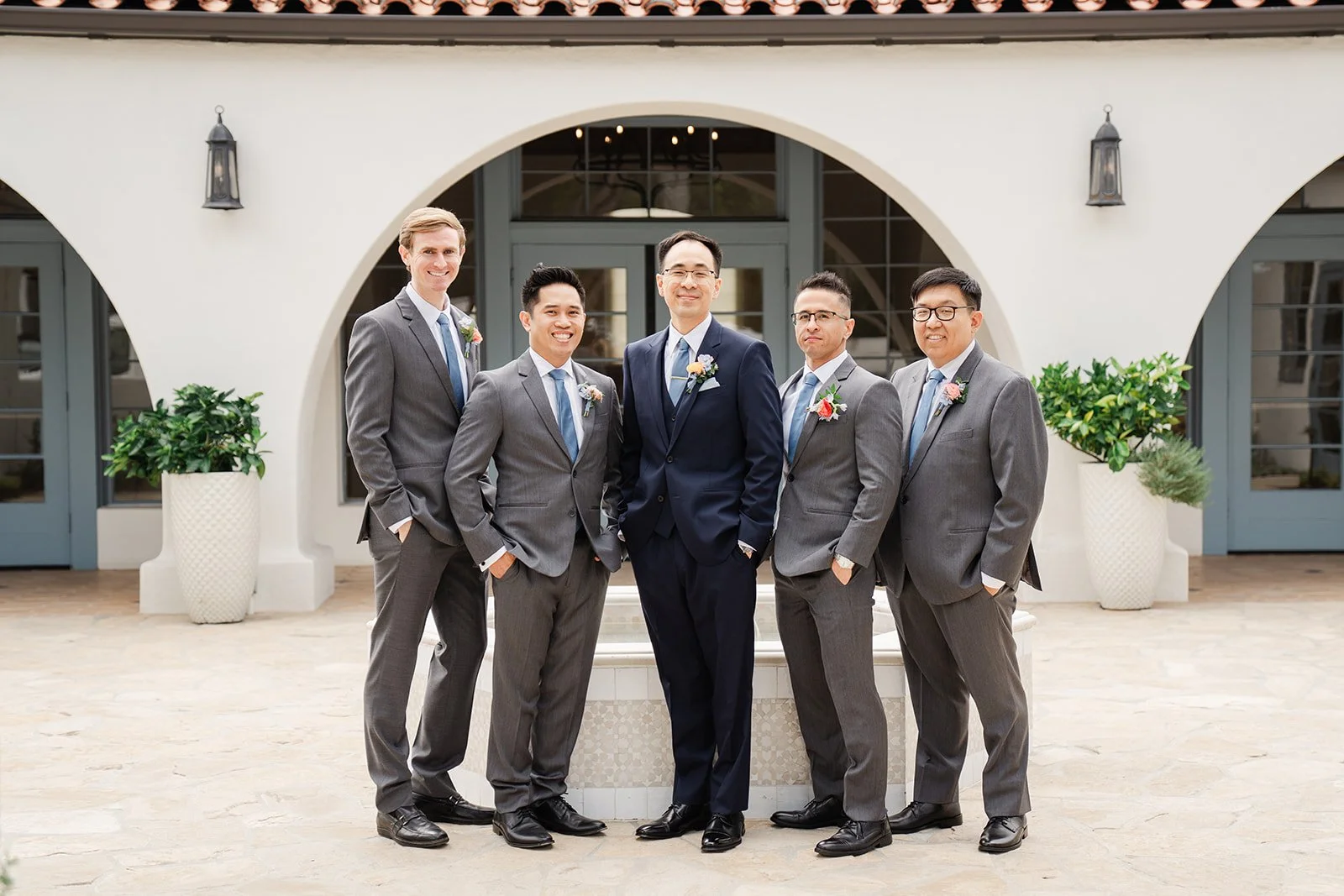 Lawrence with his groomsmen in grey suits in the Grand Gimeno courtyard