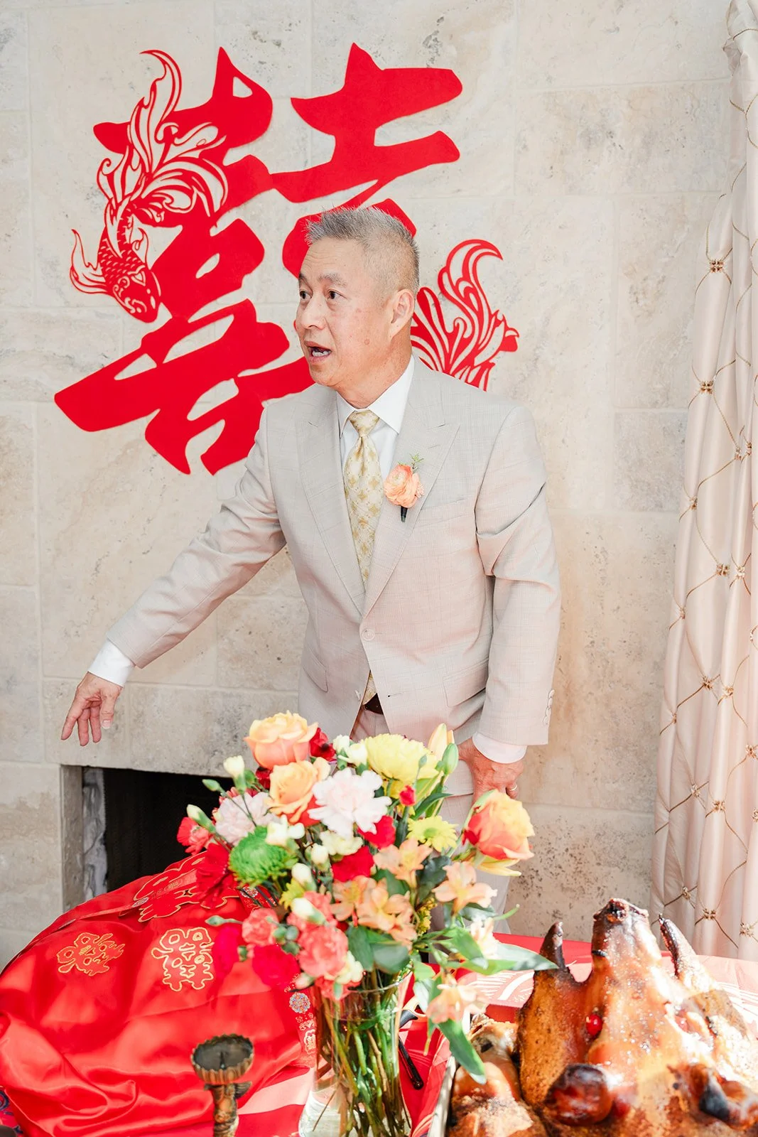 A family member standing by a large double happiness papercut as the groom's side arrives.