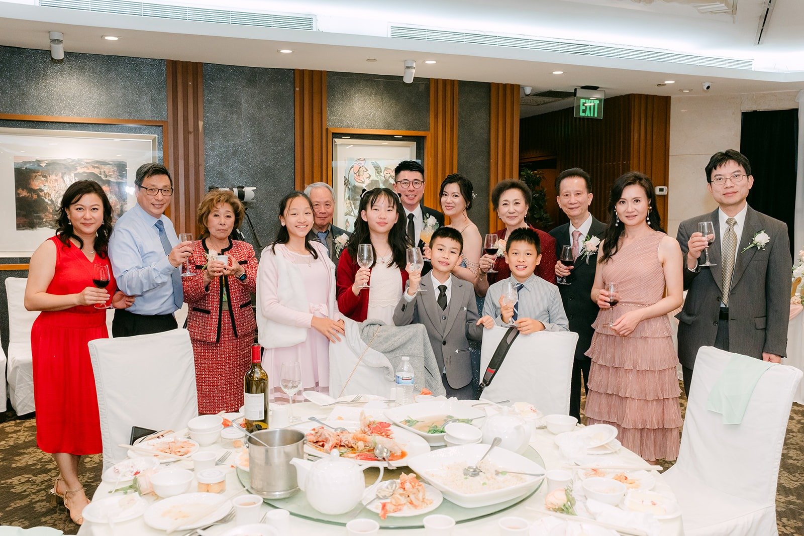 A full table of guests stands for a group photo with the couple