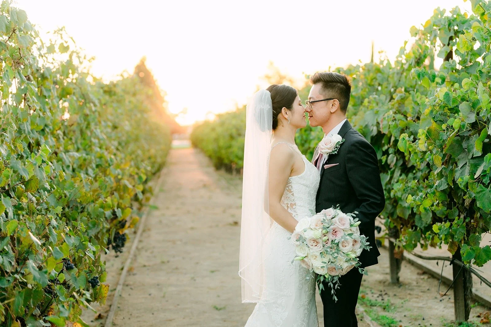 Xuemin and Alex in the vineyard as the sun sets behind them