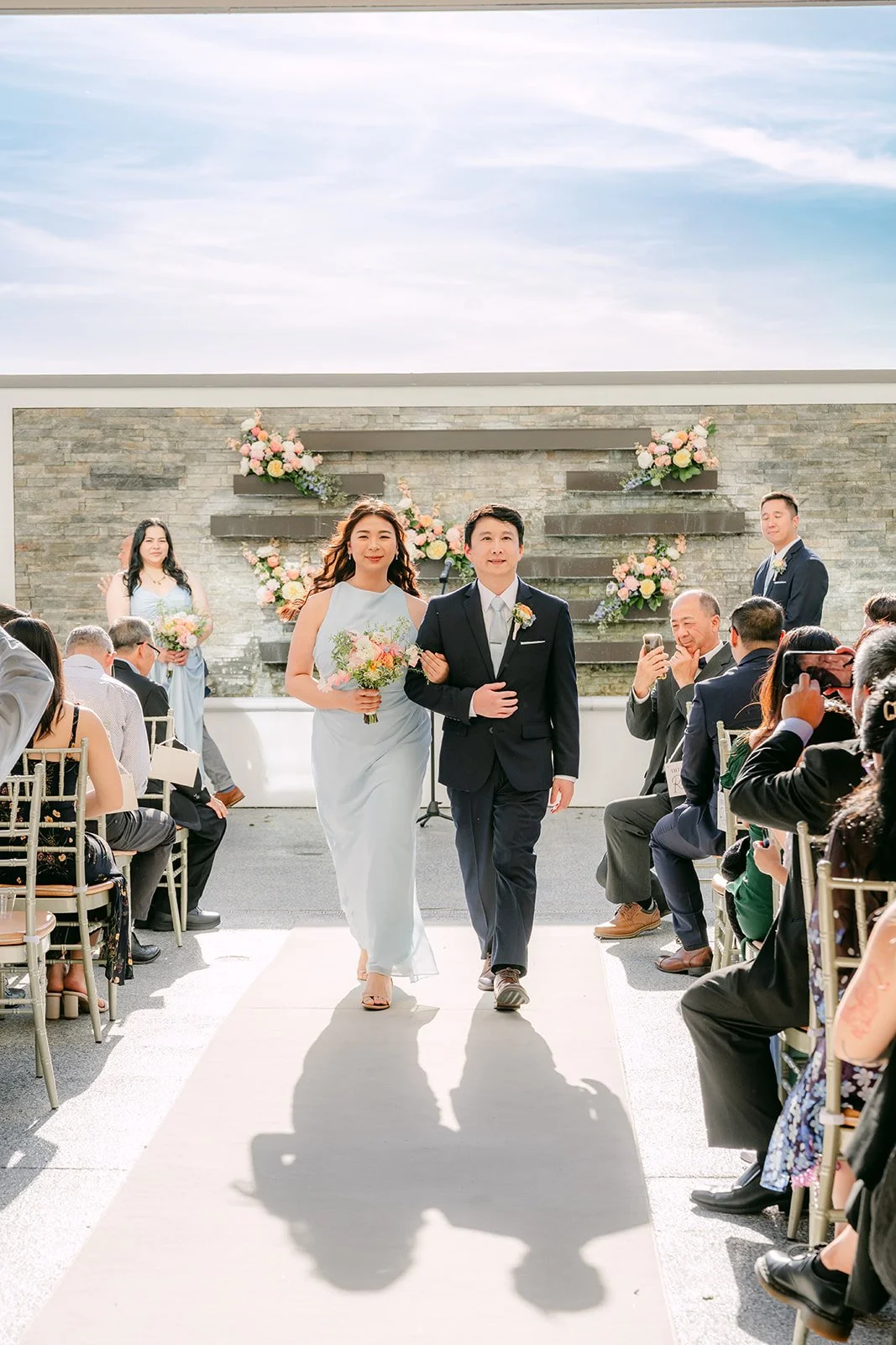 Guests cheering as Amanda and San leave the ceremony, photographed by One and Only Production.