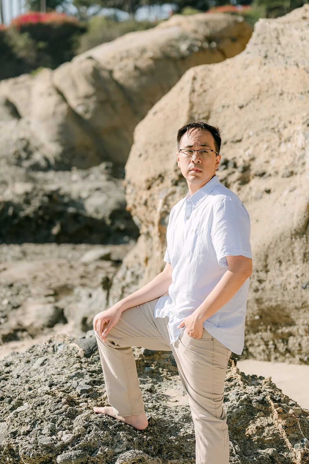 Lawrence on the rocks in his linen shirt, photographed by One and Only Production.