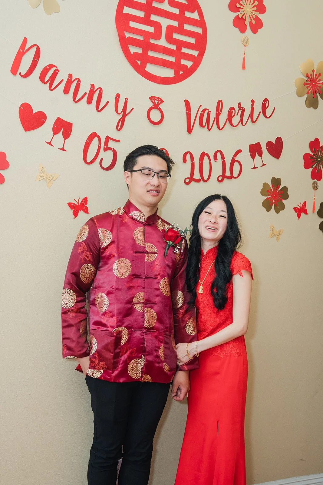 Valerie and Danny in front of their name backdrop.