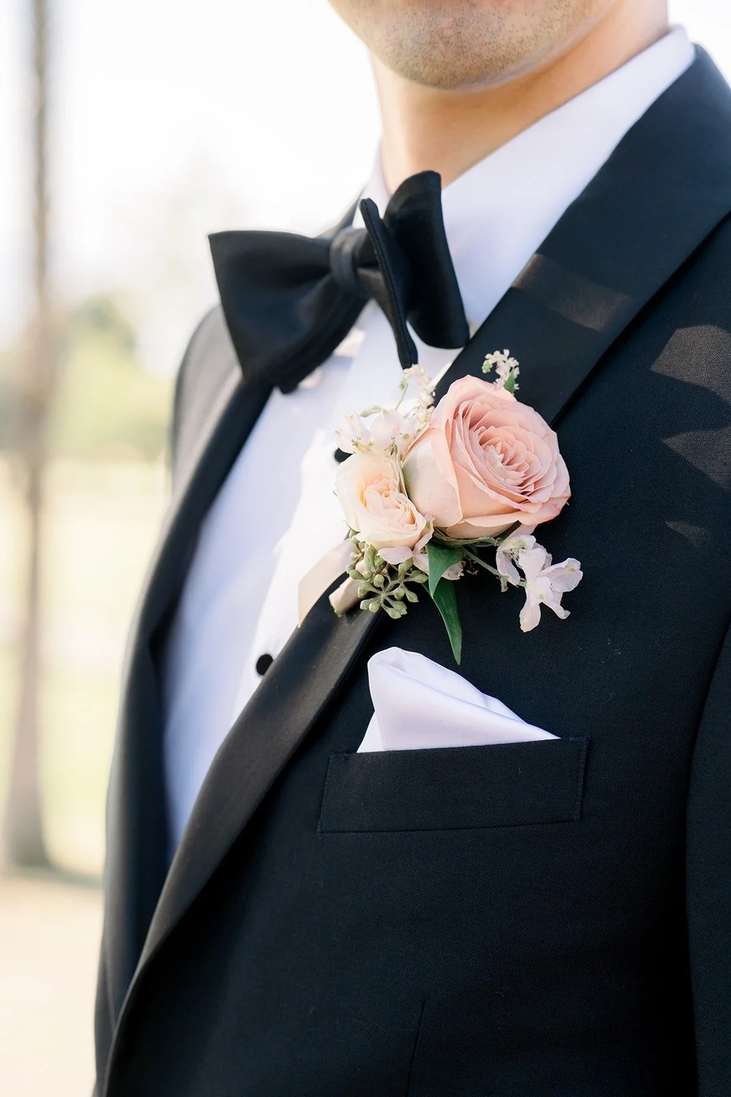 Close up of David's bow tie and pink rose boutonniere