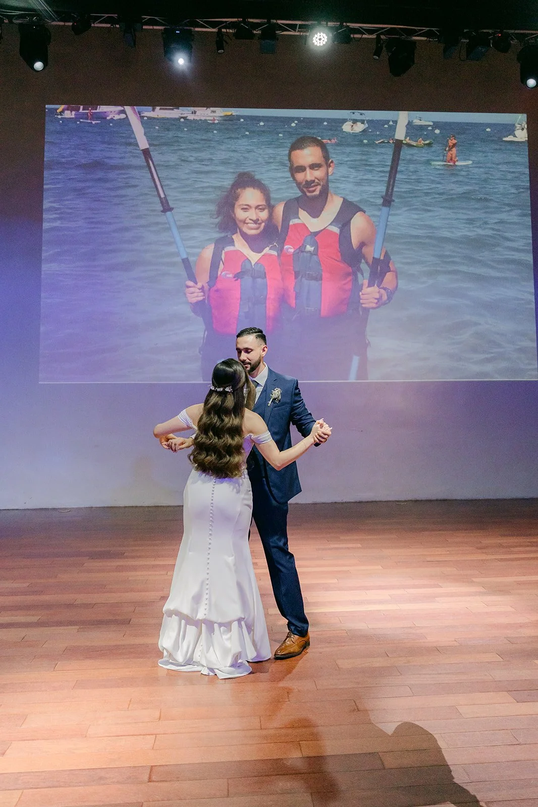 First dance in front of the projector screen playing their slideshow