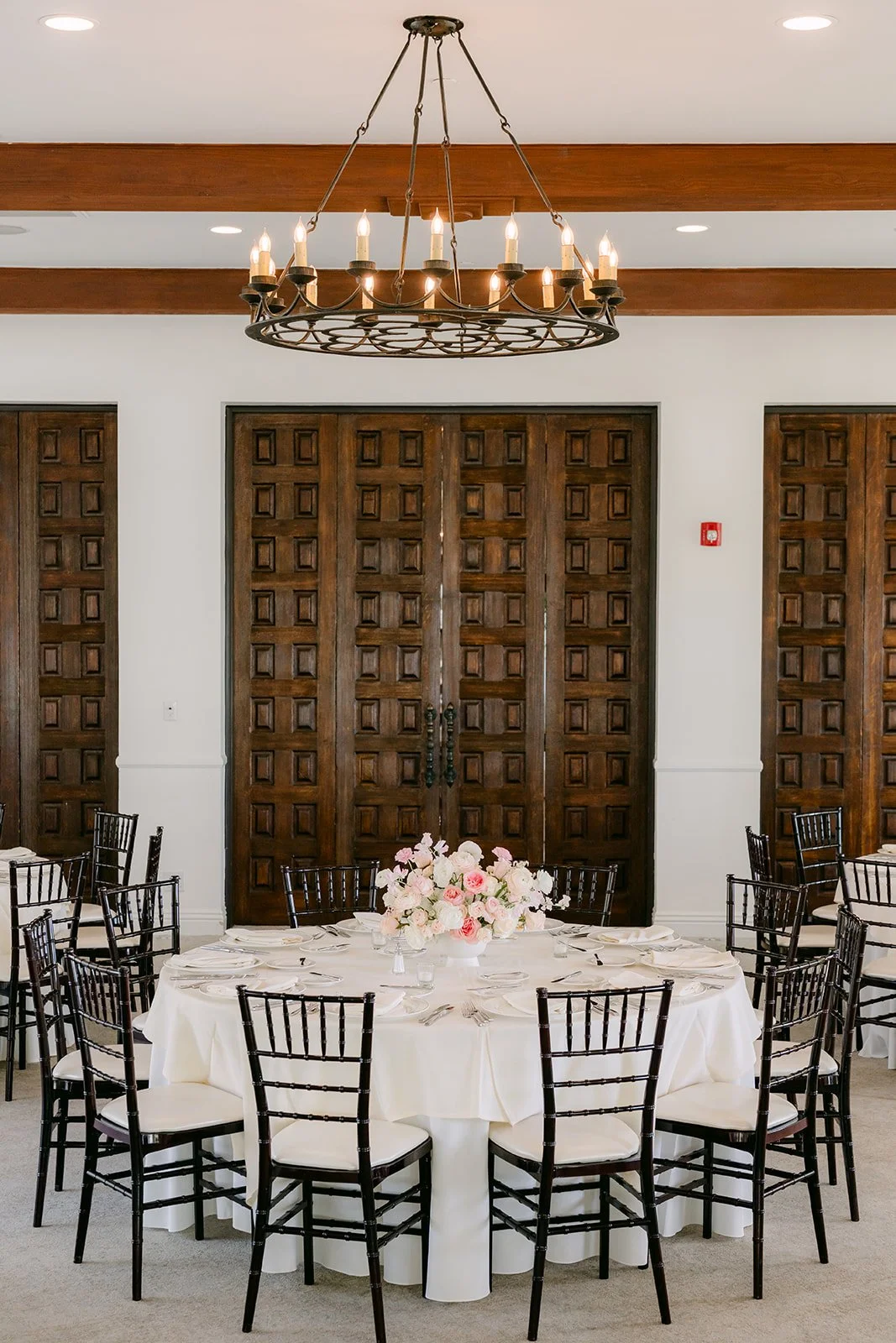 Round reception table under a wrought iron chandelier