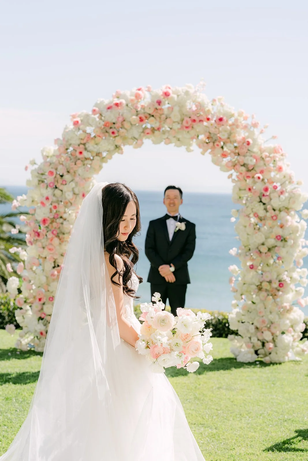 Bride and groom standing under the floral arch