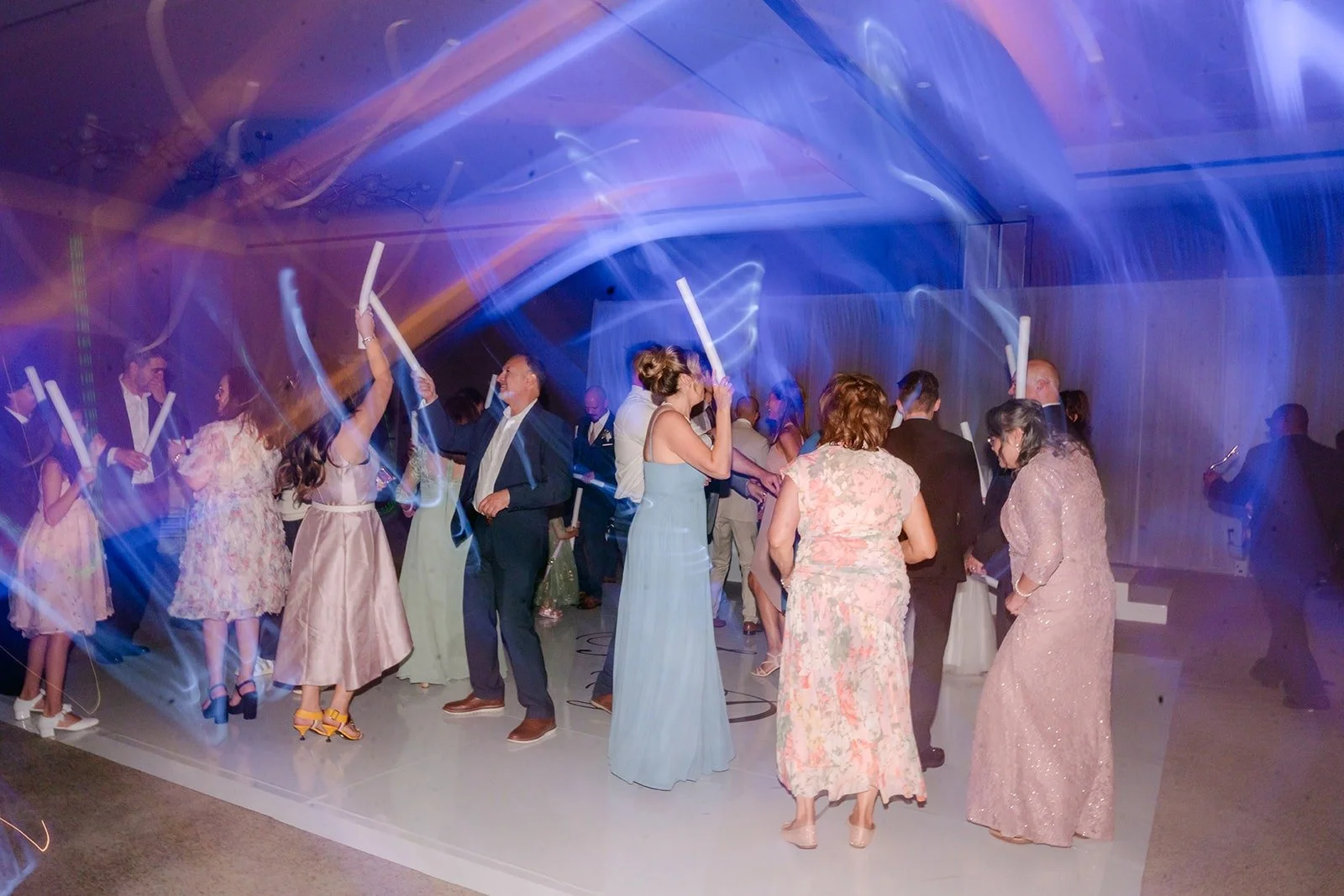 Guests wave light sticks on the dance floor
