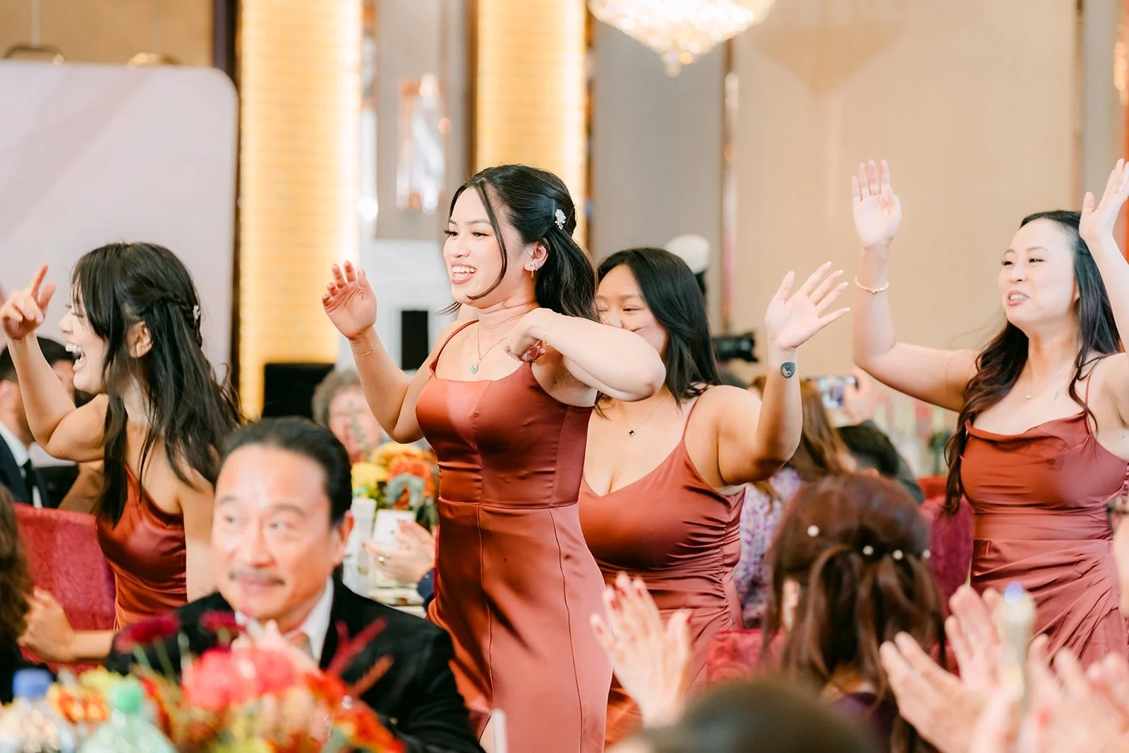Bridesmaids in rose gowns dance their way in