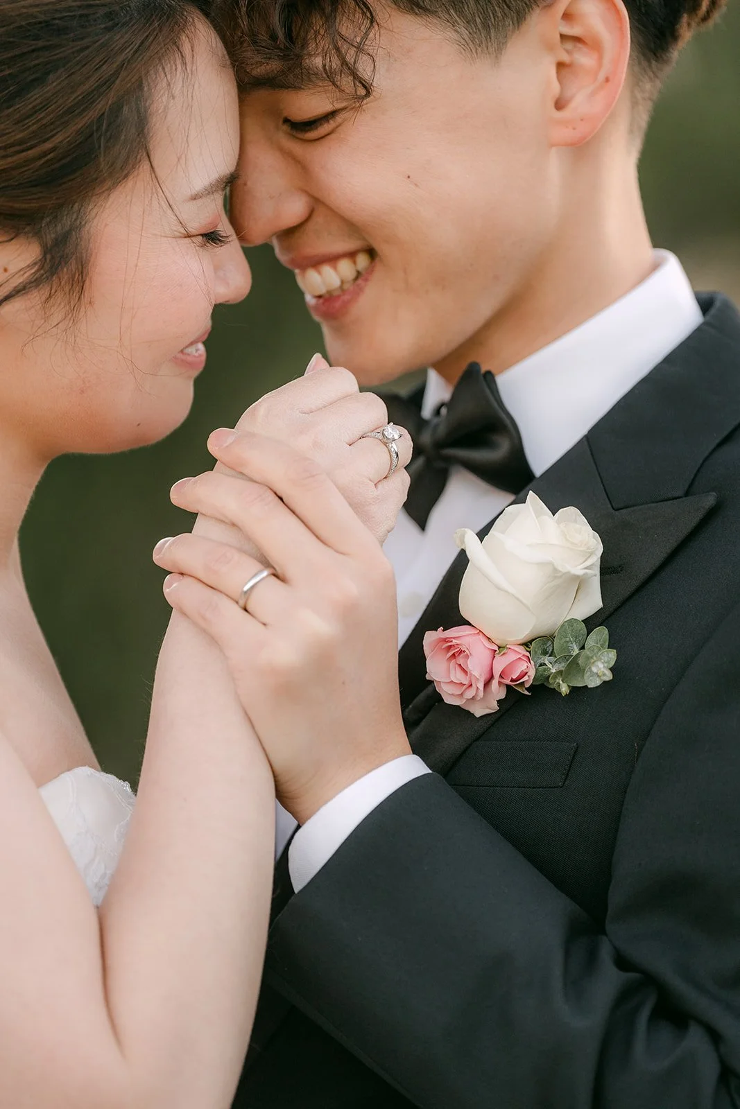 Close-up of the bride and groom with hands clasped and eyes closed