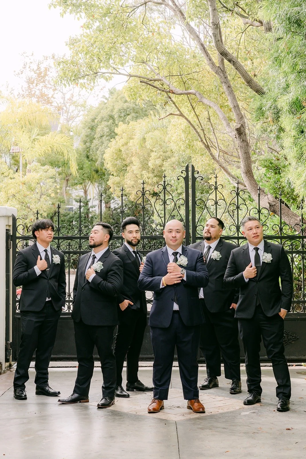 Yao and his groomsmen lined up by the iron gate