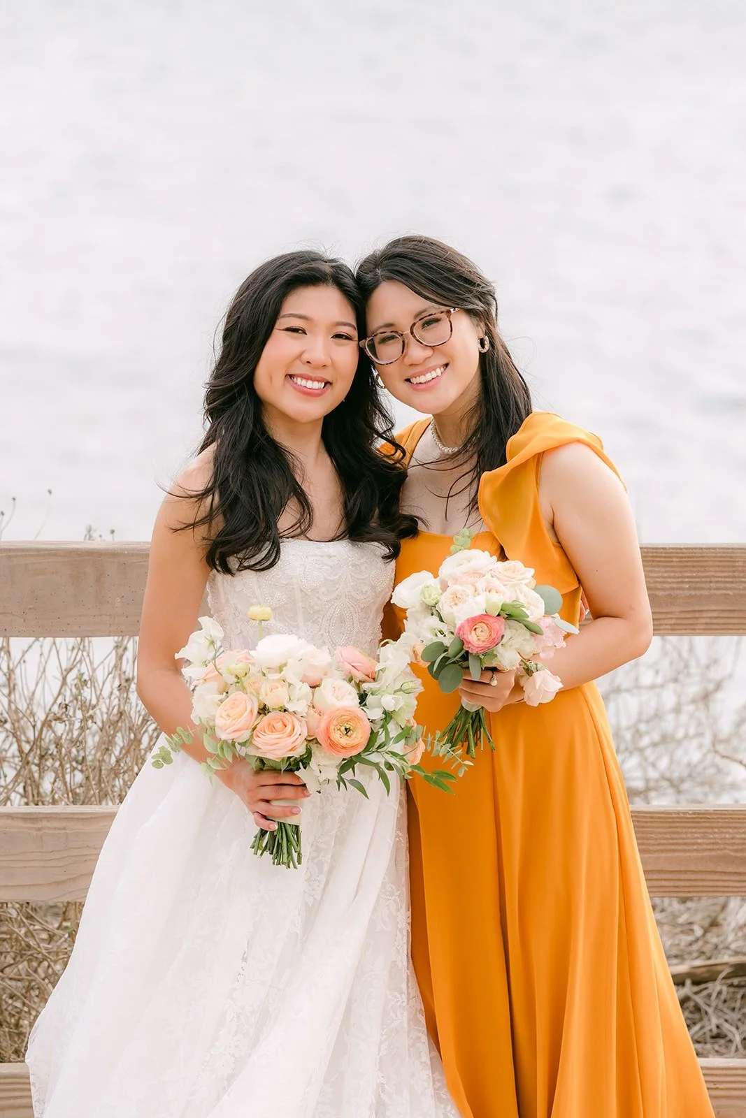 Kim hugging a bridesmaid by the ocean