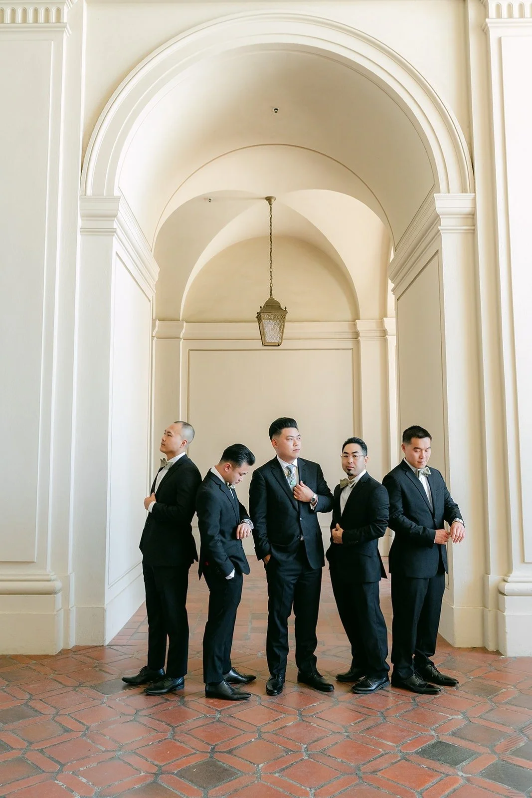 Vincent and his groomsmen under the arched hallway