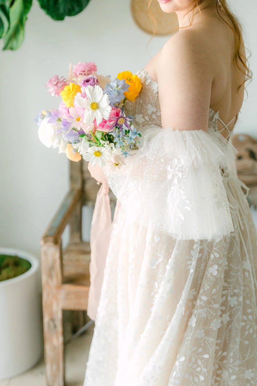 Joanna holding her pastel bouquet with sheer puff sleeves off her shoulders